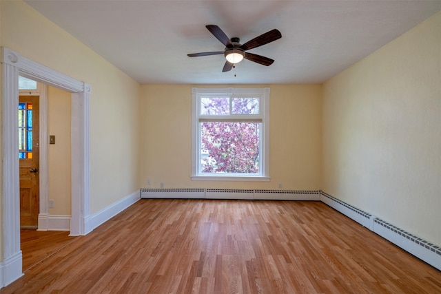 unfurnished room with a baseboard radiator, light wood-style flooring, ceiling fan, and baseboards