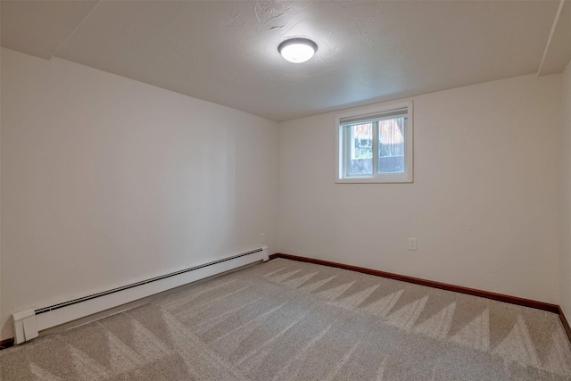 carpeted spare room with a baseboard heating unit and baseboards