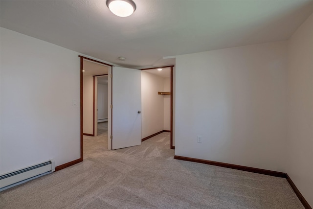unfurnished room with a baseboard radiator, light carpet, and baseboards