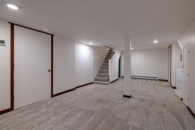finished below grade area with a baseboard heating unit, carpet floors, stairway, recessed lighting, and baseboards