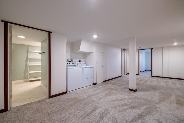 finished basement with washer and clothes dryer, light colored carpet, and baseboards