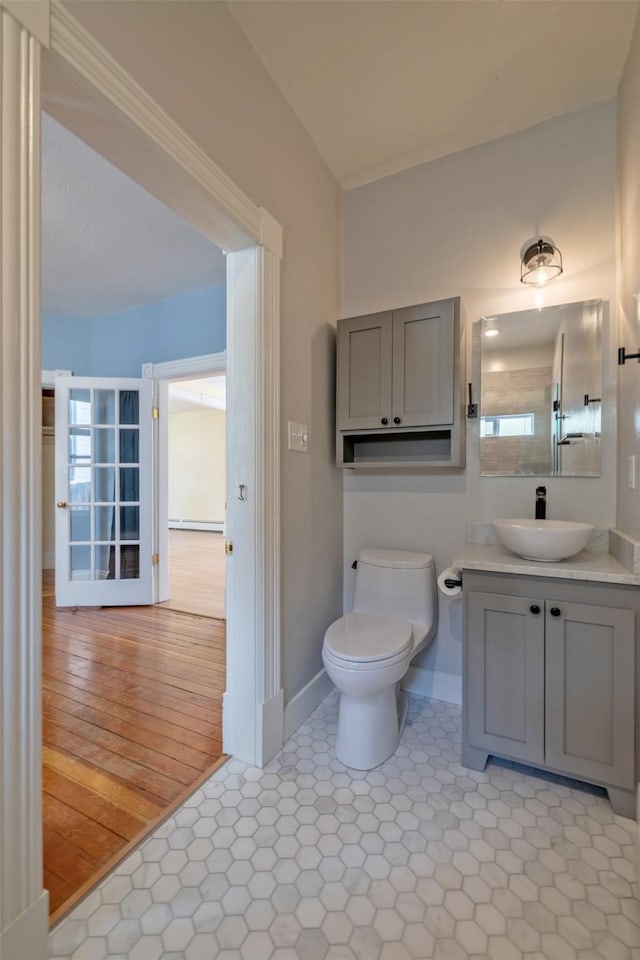 bathroom with toilet, baseboards, vanity, and baseboard heating
