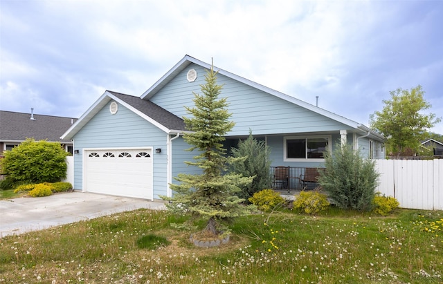 view of front of home with driveway, a garage, fence, and a porch