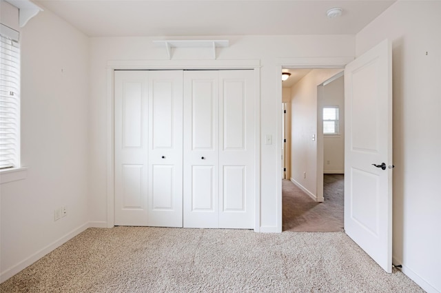 unfurnished bedroom featuring carpet, a closet, and baseboards
