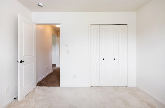 unfurnished bedroom featuring carpet flooring, a closet, and baseboards