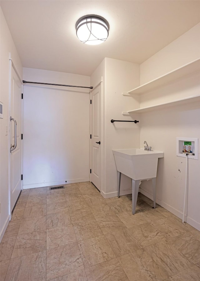 laundry room featuring washer hookup and baseboards