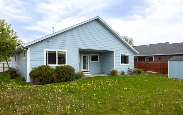 back of property featuring entry steps and an outdoor structure