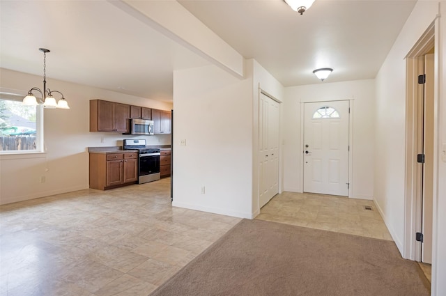 entryway with a chandelier, plenty of natural light, and baseboards
