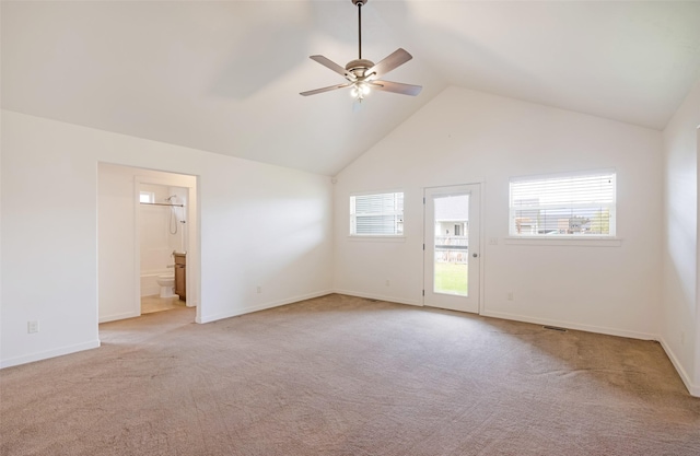 empty room with ceiling fan, light carpet, vaulted ceiling, and baseboards