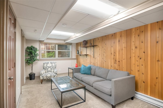 carpeted living area featuring a baseboard radiator, wood walls, and baseboards