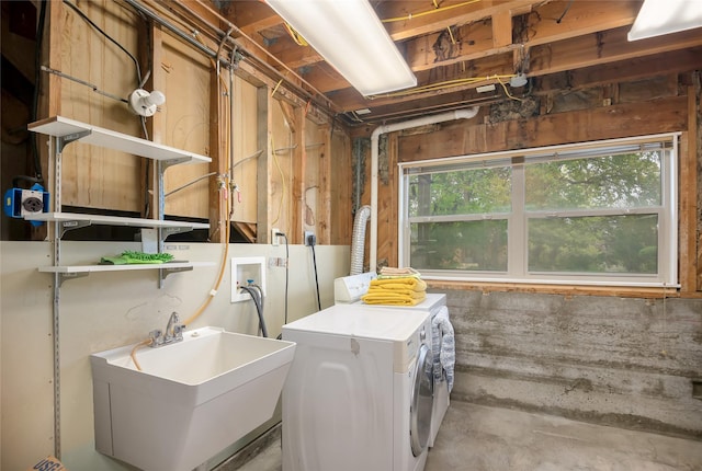 basement with washer and clothes dryer and a sink