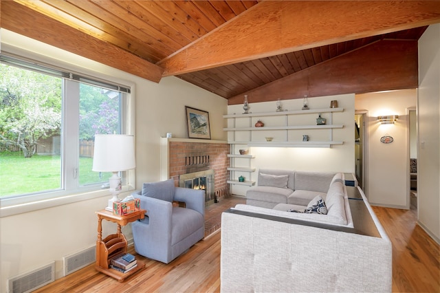 living area with wooden ceiling, plenty of natural light, a fireplace, and light wood-style flooring