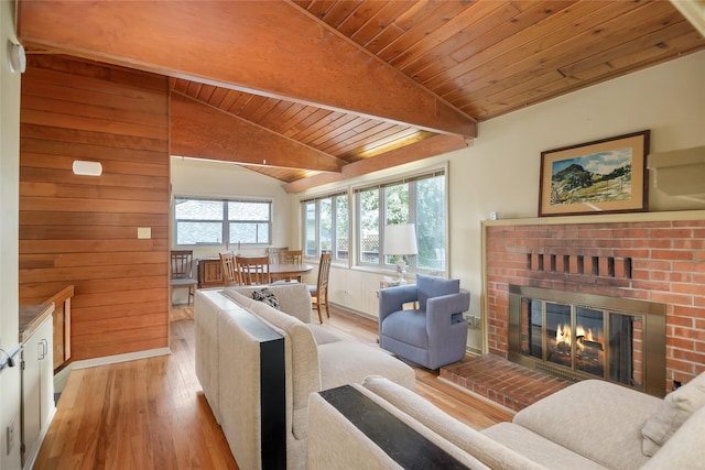 living area featuring light wood-type flooring, a fireplace, and wooden ceiling