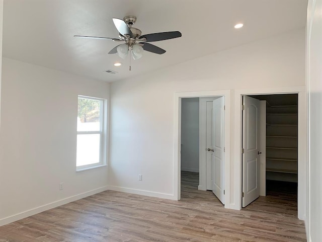 998 Mount Silcox Dr, Thompson Falls, MT 59873 - unfurnished bedroom featuring a walk in closet, light wood-type flooring, recessed lighting, a closet, and ceiling fan