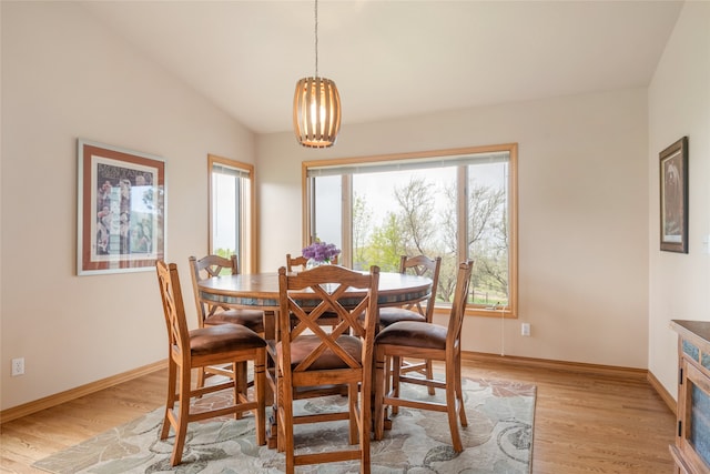 5190 Goodan Ln, Missoula, MT 59808 - dining area featuring light wood-type flooring, vaulted ceiling, baseboards, and a chandelier