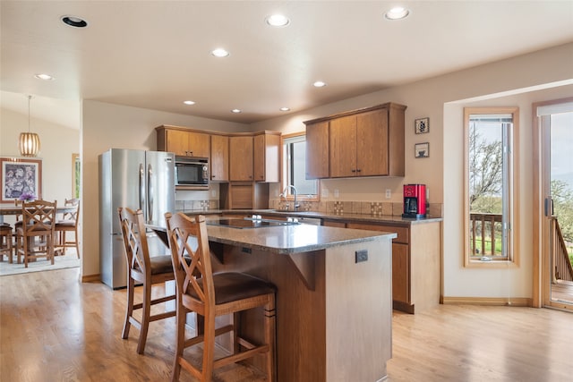 5190 Goodan Ln, Missoula, MT 59808 - kitchen featuring freestanding refrigerator, built in microwave, recessed lighting, a kitchen island, and light wood-style flooring