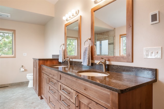 5190 Goodan Ln, Missoula, MT 59808 - bathroom with toilet, double vanity, tile patterned floors, baseboards, and a shower