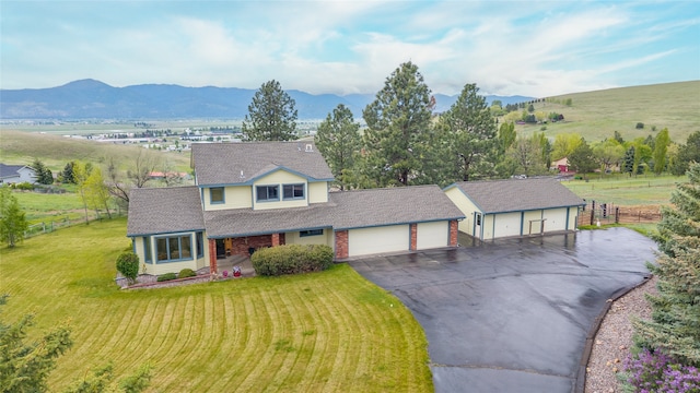 5190 Goodan Ln, Missoula, MT 59808 - traditional home featuring asphalt driveway, an attached garage, a mountain view, roof with shingles, and covered porch