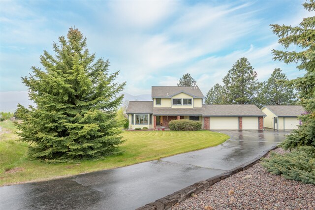 5190 Goodan Ln, Missoula, MT 59808 - traditional-style house featuring asphalt driveway, an attached garage, and a front lawn