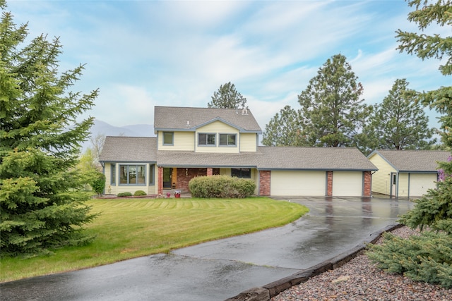 5190 Goodan Ln, Missoula, MT 59808 - traditional-style house featuring asphalt driveway, a garage, a front yard, roof with shingles, and a mountain view