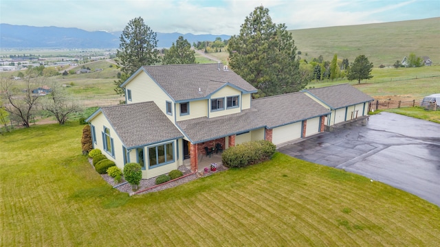 5190 Goodan Ln, Missoula, MT 59808 - view of front of property featuring a shingled roof, asphalt driveway, an attached garage, a mountain view, and a porch