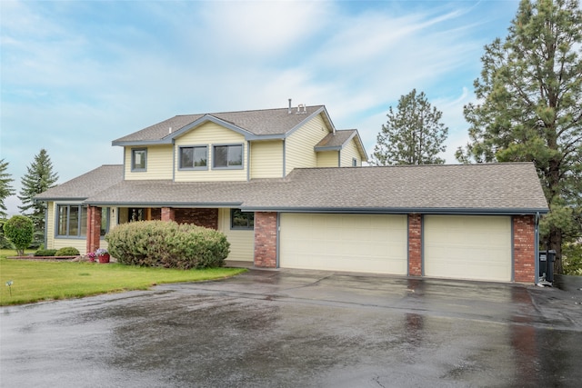 5190 Goodan Ln, Missoula, MT 59808 - view of front of home with asphalt driveway, a garage, a shingled roof, and brick siding