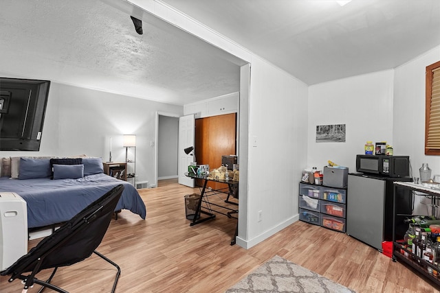 bedroom with light wood-type flooring and baseboards