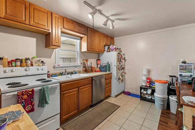 kitchen featuring white appliances, a sink, light countertops, light tile patterned flooring, and brown cabinets