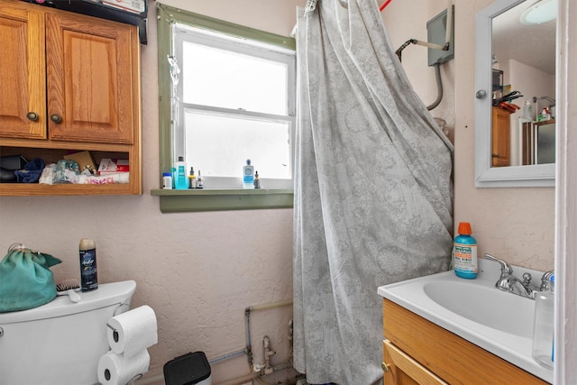 full bathroom with toilet and vanity