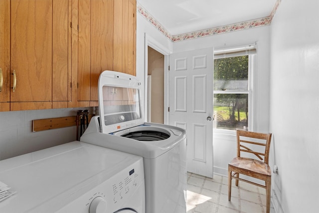 laundry area with cabinet space, washing machine and dryer, and light flooring