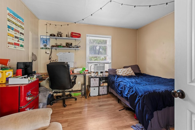 bedroom featuring wood finished floors, cooling unit, and a desk