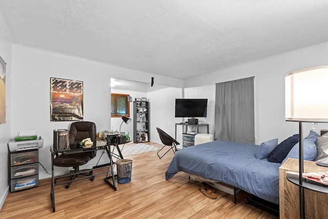 bedroom featuring light wood finished floors and baseboards