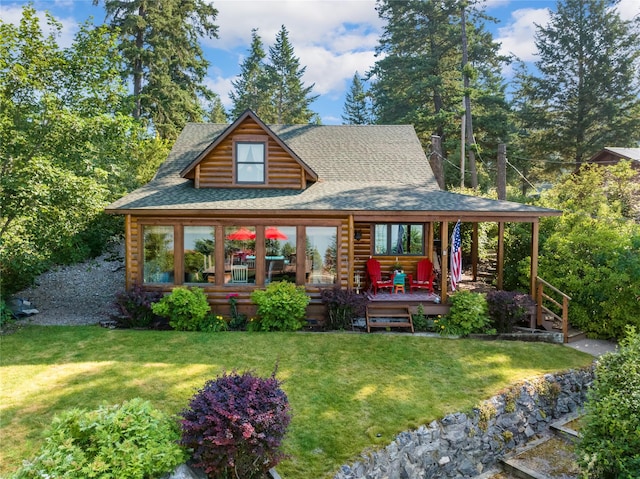 15222 Mt Highway 35, Bigfork, MT 59911 - view of front facade with roof with shingles, a front lawn, a wooden deck, and log exterior