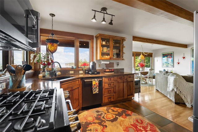 15222 Mt Highway 35, Bigfork, MT 59911 - kitchen with stainless steel appliances, a sink, brown cabinetry, beamed ceiling, and glass insert cabinets