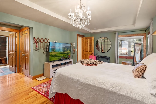 15222 Mt Highway 35, Bigfork, MT 59911 - bedroom with a tray ceiling, wood finished floors, a chandelier, and baseboards
