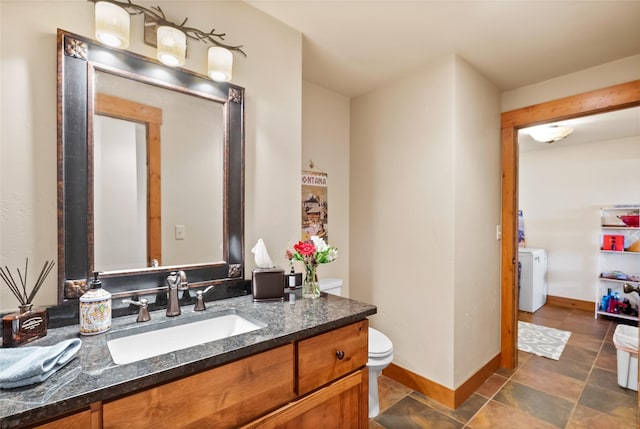 15222 Mt Highway 35, Bigfork, MT 59911 - bathroom with washer / clothes dryer, baseboards, vanity, and toilet