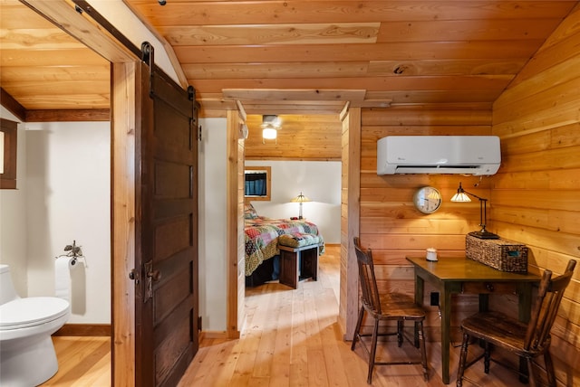 15222 Mt Highway 35, Bigfork, MT 59911 - hall with a wall unit AC, a barn door, light wood-style floors, wood ceiling, and vaulted ceiling