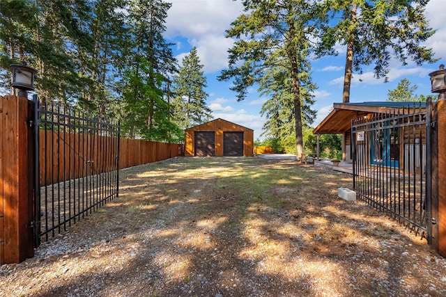 15222 Mt Highway 35, Bigfork, MT 59911 - view of yard with a detached garage, fence, an outbuilding, a gate, and dirt driveway