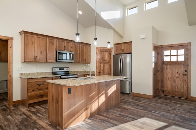 kitchen featuring appliances with stainless steel finishes, a sink, high vaulted ceiling, dark wood finished floors, and brown cabinetry