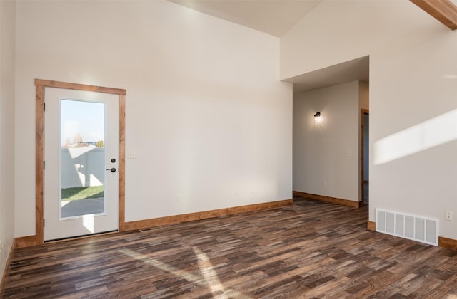 unfurnished room featuring dark wood-style flooring, high vaulted ceiling, and baseboards