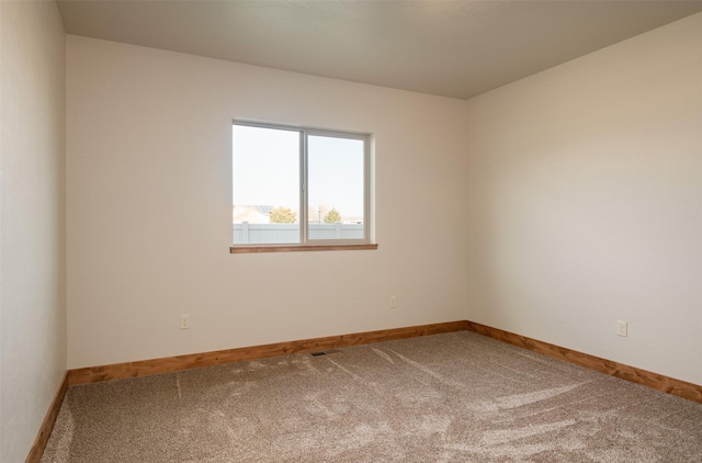 carpeted empty room with baseboards