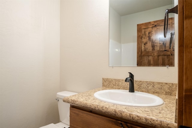 half bathroom featuring vanity and toilet