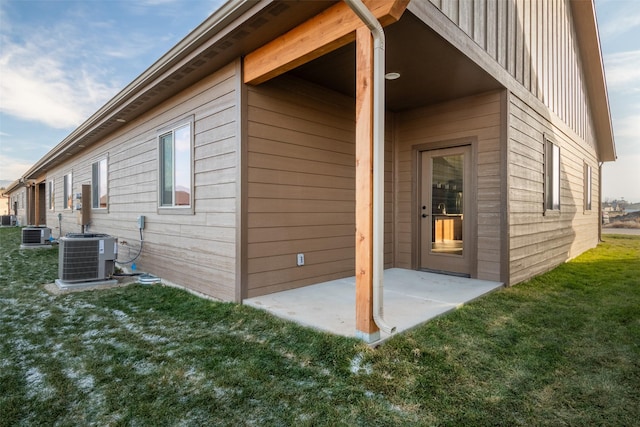 view of home's exterior featuring cooling unit, a patio area, a yard, and board and batten siding