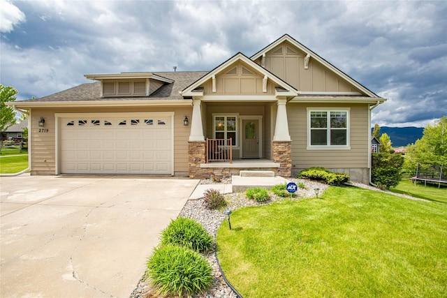 2719 Carnoustie Way, Missoula, MT 59808 - view of front facade featuring a trampoline, a porch, driveway, a front yard, and an attached garage