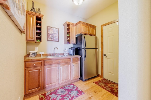 4340 Fox View Loop, Helena, MT 59602 - kitchen featuring open shelves, freestanding refrigerator, light wood-style flooring, a sink, and light countertops