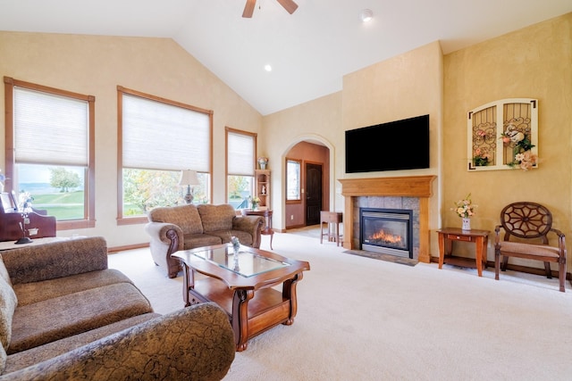 4340 Fox View Loop, Helena, MT 59602 - living area with carpet floors, arched walkways, a tiled fireplace, a ceiling fan, and high vaulted ceiling