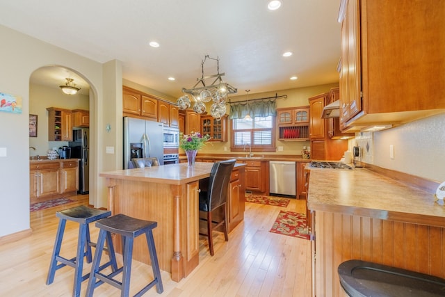 4340 Fox View Loop, Helena, MT 59602 - kitchen featuring appliances with stainless steel finishes, a kitchen breakfast bar, light wood-type flooring, glass insert cabinets, and recessed lighting