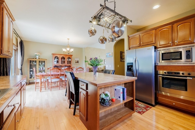 4340 Fox View Loop, Helena, MT 59602 - kitchen with appliances with stainless steel finishes, light countertops, light wood-style flooring, a kitchen island, and a chandelier