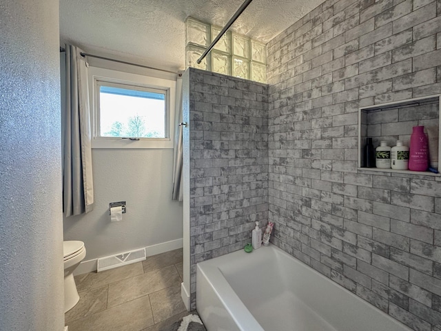 604 27th Ave NE, Great Falls, MT 59404 - full bath featuring baseboards, toilet, a textured ceiling, shower / bathtub combination, and tile patterned flooring