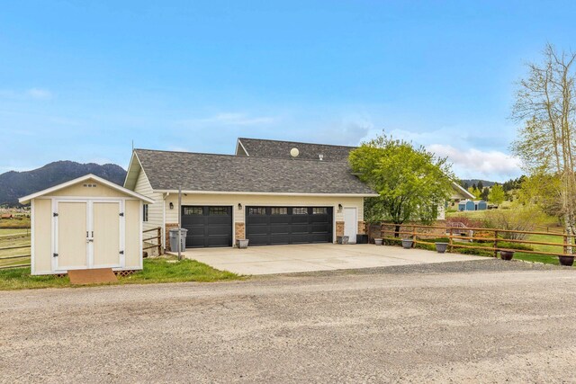 207 Cyprus Dr, Butte, MT 59701 - view of front of home featuring a garage, fence, driveway, and an outdoor structure